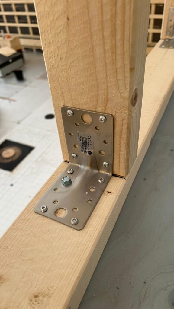 Kulmarauta kiinnitettynä ankkuriruuvilla puurunkoon